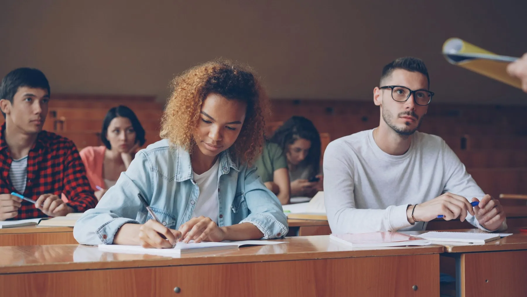 Students working through an examination in a lecture hall